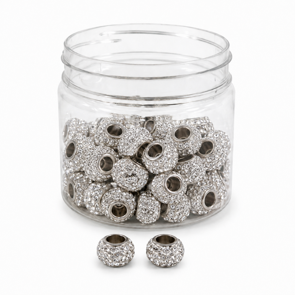 A clear plastic jar filled with silver-toned round beads covered in small clear rhinestones