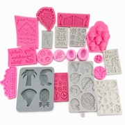 Assorted silicone molds featuring crowns, cupcakes, fairy, palm tree, garden gate and decorative details