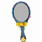 Back of decorated mermaid hand mirror with colorful beaded border, floral handle and gray mirror surface