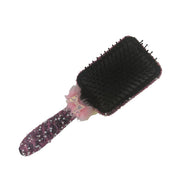 Back view of a black hair brush showing the detailed handmade fuchsia sparkling design on the handle and base