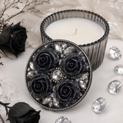 Black glitter rose cabochons decorating a candle lid with crystals and silver details in a gothic glam style.