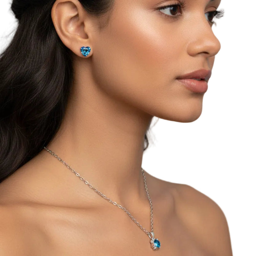 Blue crystal heart stud earrings worn by model, showing the size and sparkle of the earrings