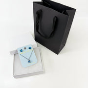 Blue heart jewelry gift set with crystal heart stud earrings, matching necklace, white gift box, and black gift bag