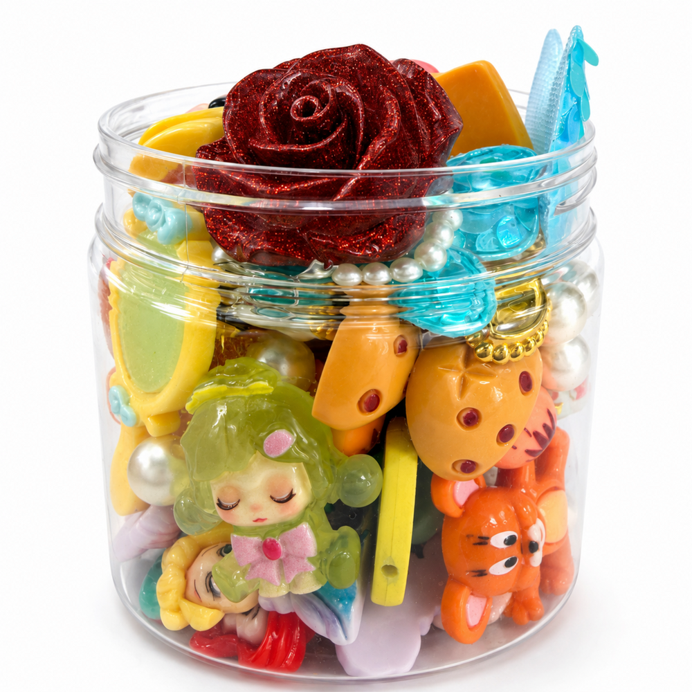 Clear display container filled with princess-inspired figures, flowers, pearls and colorful DIY craft charms.
Side view of magical craft assortment featuring mermaid tails, character charms, glitter and pearl accents.