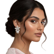 Close-up of faux pearl flower earrings with gold-tone details and sparkling crystal petals