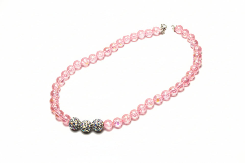 Close-up of handcrafted pet jewelry featuring high-quality pink faux pearls and professional finish