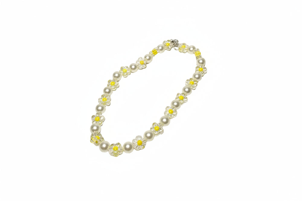Close-up of handcrafted pet jewelry with yellow flower beads and smooth white pearls for small dog breeds