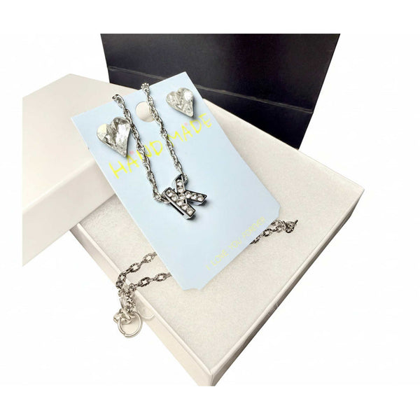 Close-up of initial K pendant necklace and crystal heart drop earrings set

