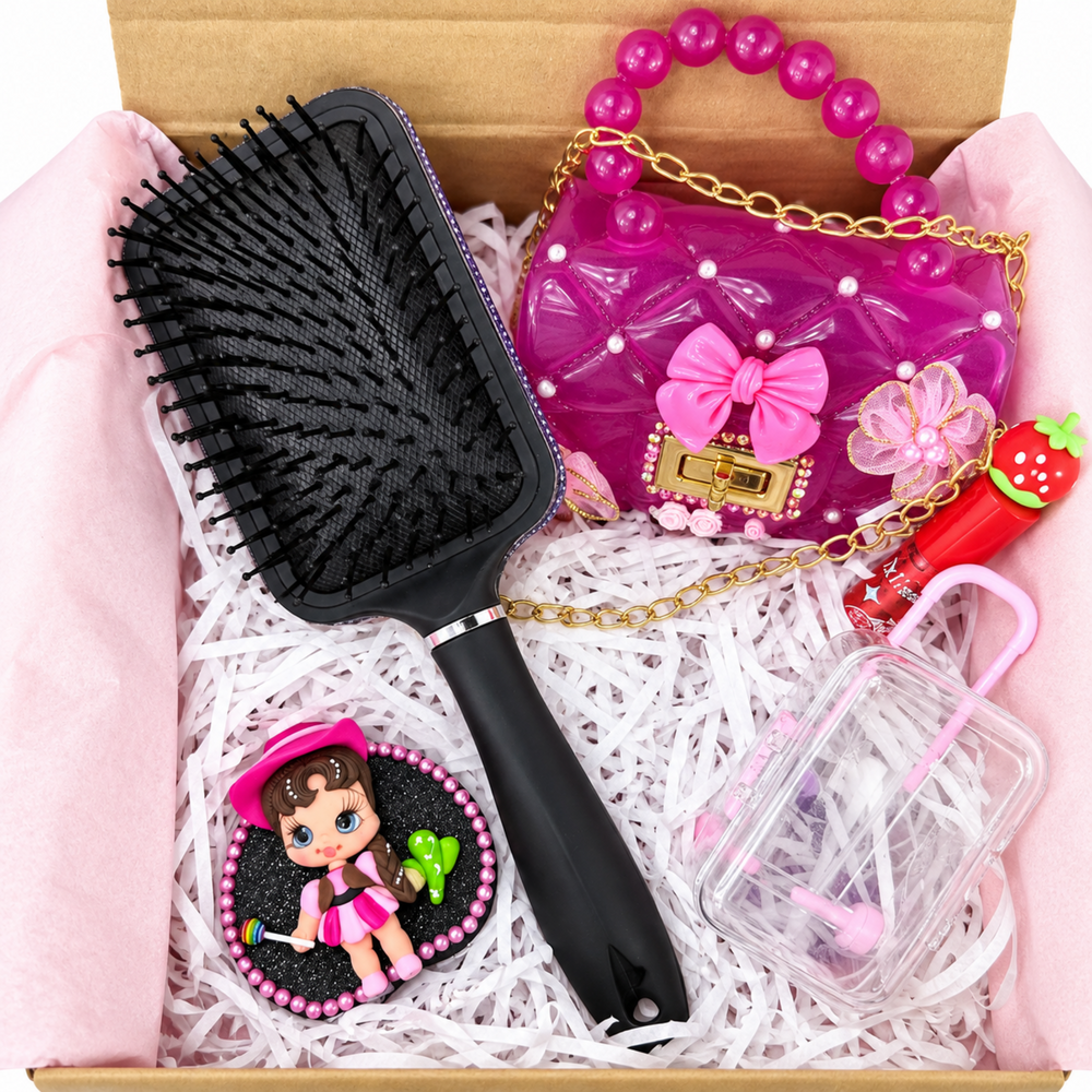 Close-up of pink cowgirl clay figure on black glitter base with pearl trim beside a decorated black hairbrush handle.