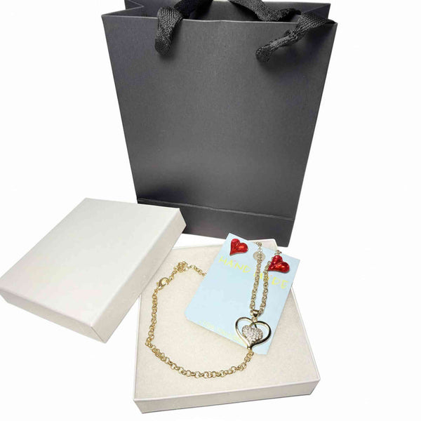 Close-up of red crystal earrings and rhinestone heart pendant necklace set
