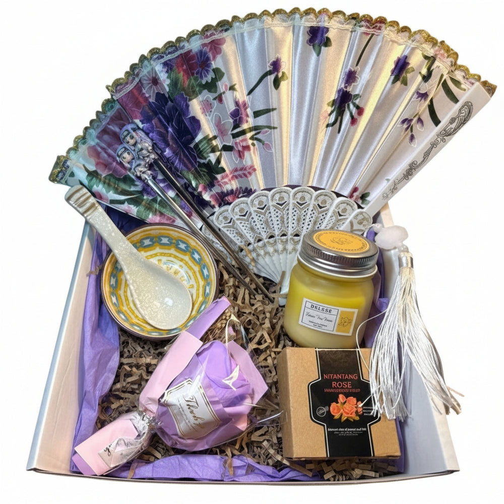 Close-up of the ceramic oriental tea bowl, matching spoon, and pink rose soap petals in a luxury wellness gift arrangement