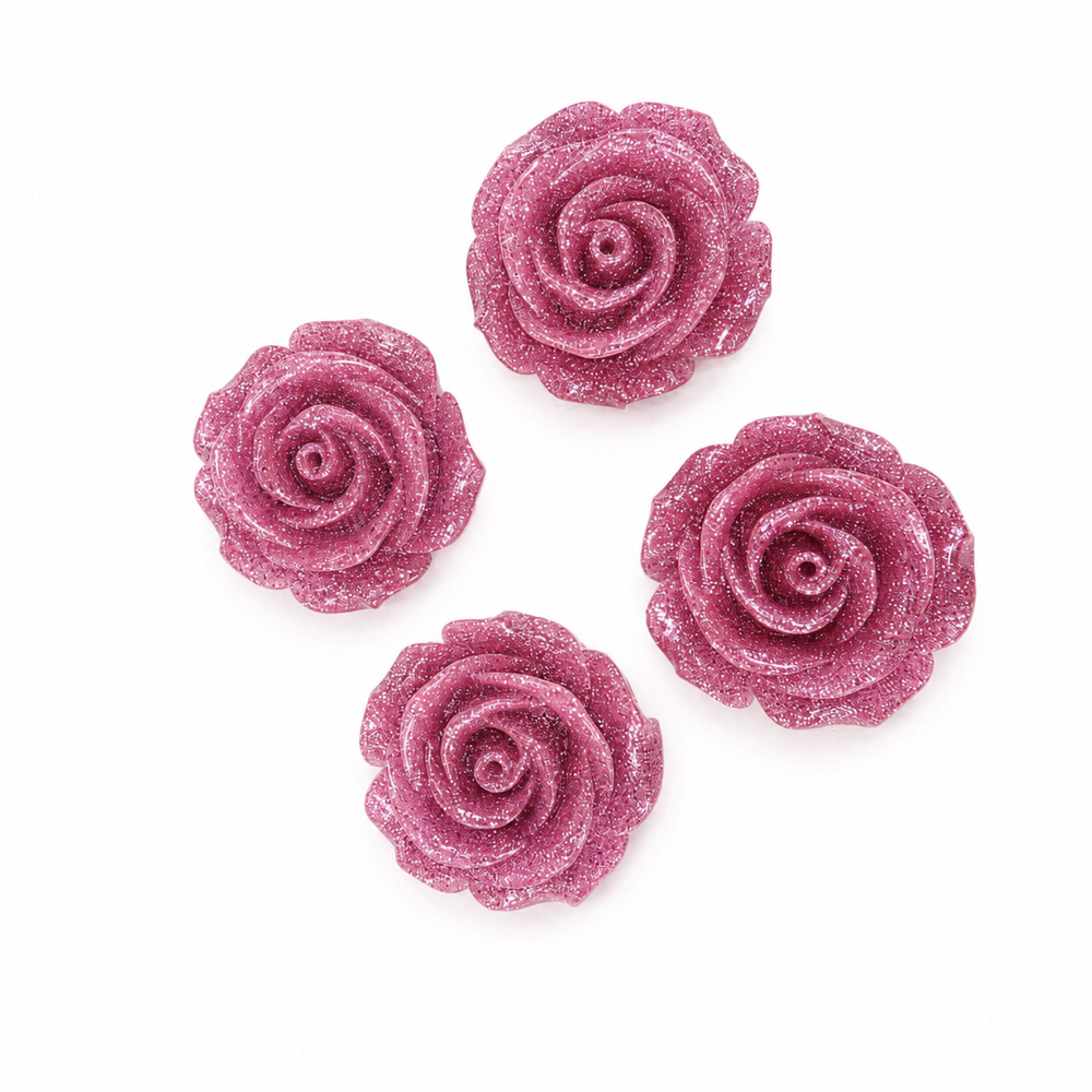 Four glittery pink rose-shaped embellishments arranged on a plain white background.