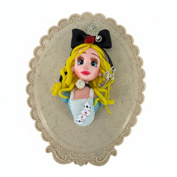 Handmade blonde doll torso with black bow, pocket watch, red crystal, and blue dress holding a silver key, 9cm flatback
