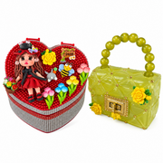 Heart-shaped rhinestone jewelry box paired with a translucent yellow-green mini purse with floral accents and beaded handle.