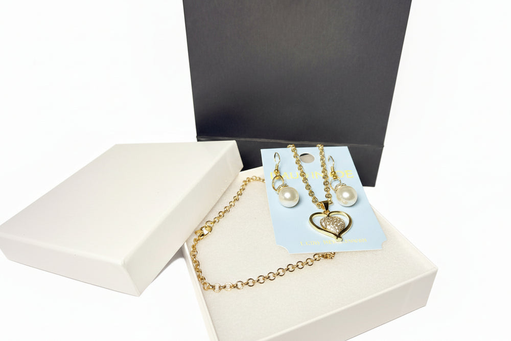 Romantic jewelry gift set with heart necklace, pearl earrings, white jewelry box, and black gift bag.