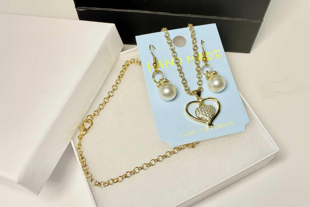 Romantic jewelry gift set with heart necklace, pearl earrings, white jewelry box, and black gift bag.