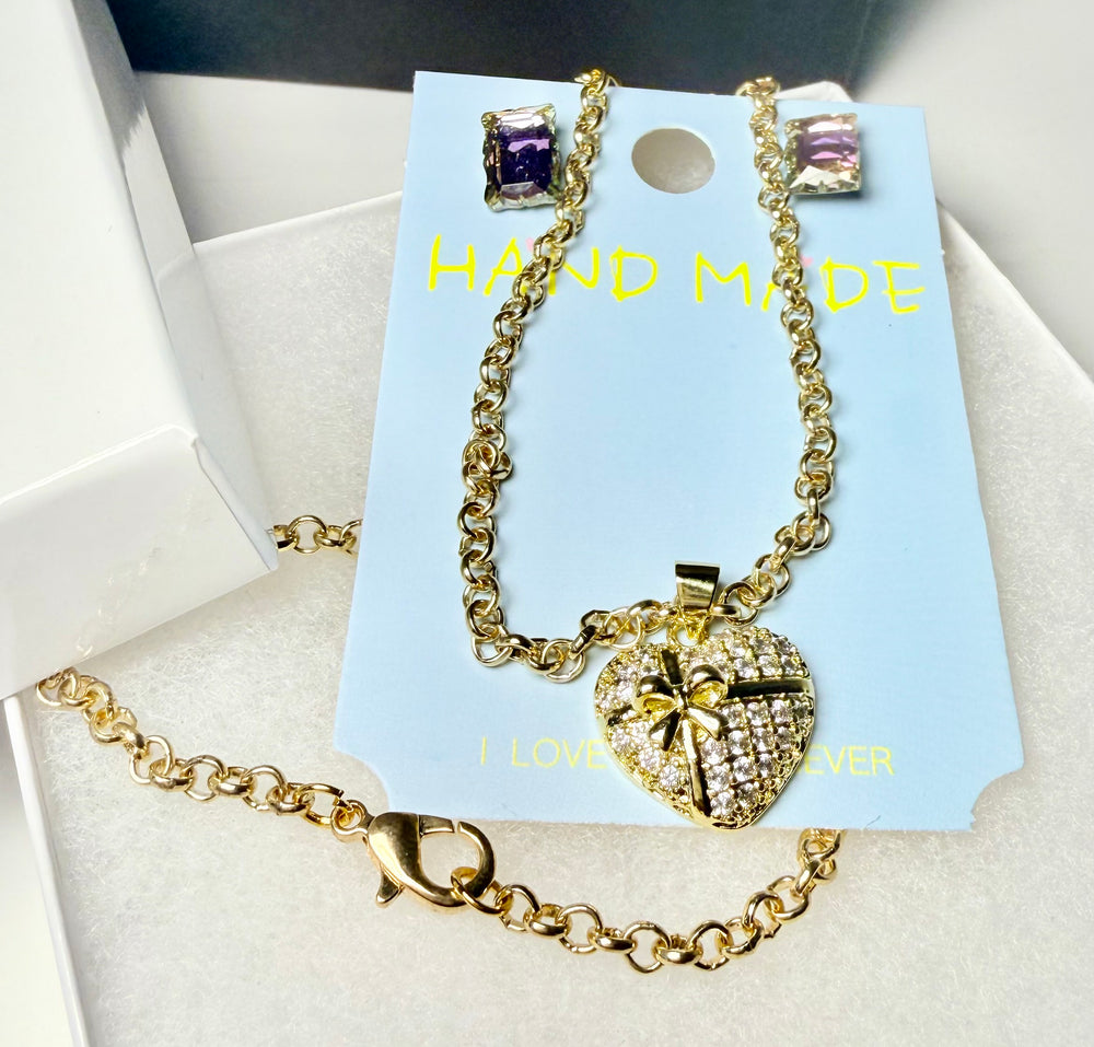 Gold-tone crystal heart necklace and earring gift set in premium packaging with gift bag close up