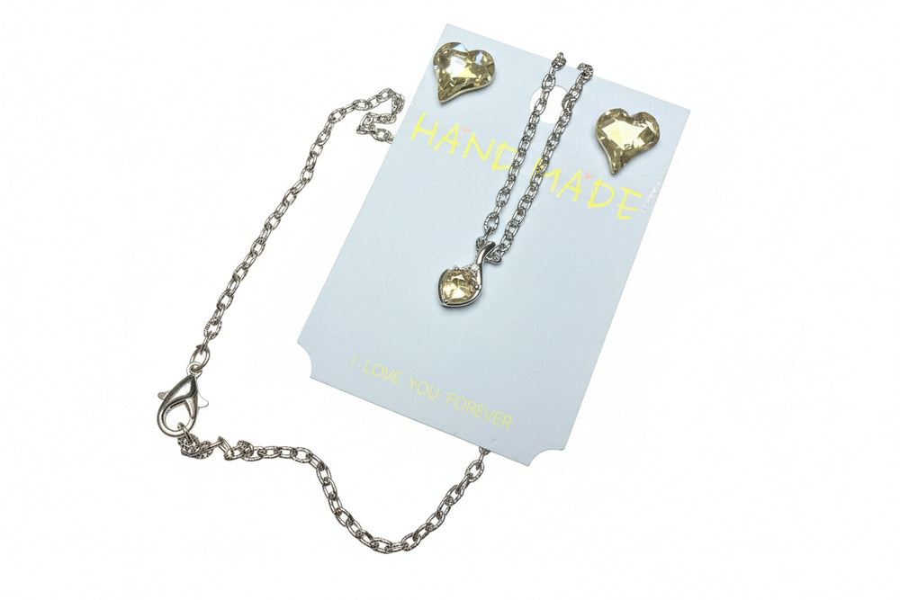 close up Heart crystal necklace and earring jewelry set displayed in a white gift box with a luxury black gift bag