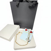 Red crystal earrings and gold-tone heart pendant necklace displayed in a white gift box with a luxury black gift bag