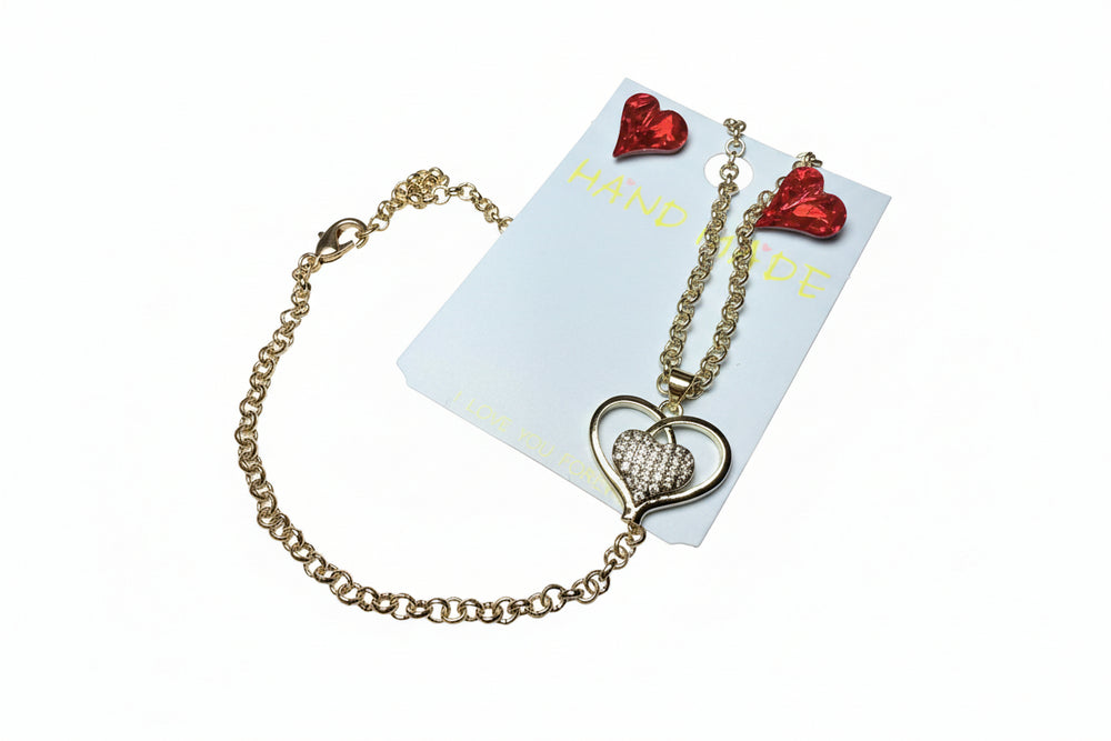 Close-up of a gold-tone heart pendant necklace displayed on a white jewelry card read crystal earrings