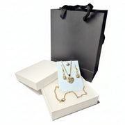 Rhinestone heart necklace and earring set displayed in a premium white gift box with a luxury black handle bag.handle bag.