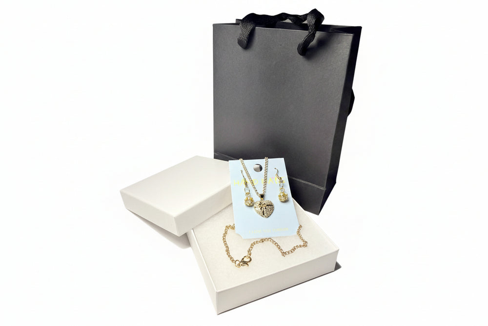 Rhinestone heart necklace and earring set displayed in a premium white gift box with a luxury black handle bag.handle bag.