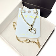 Majestic Boutique presentation: Heart and teddy bear jewelry set in a white box with a black luxury handle bag and tissue paper.