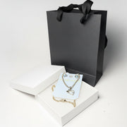 Close-up of sparkling crystal teddy bear earrings and rhinestone heart pendant on a 'Handmade' jewelry card.