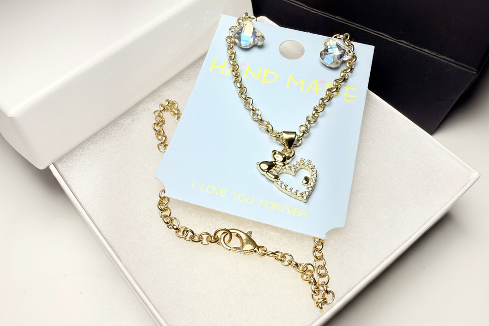 Romantic jewelry gift set with a rhinestone heart necklace, crystal teddy bear earrings, premium white box, and black gift bag.