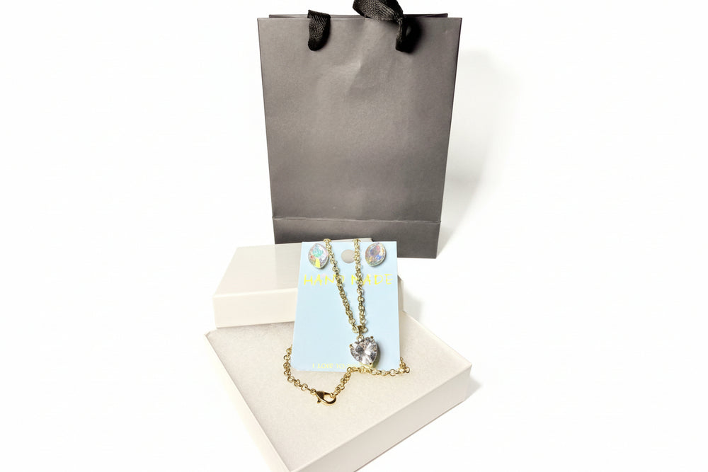 Handmade crystal necklace and earring set on a display card with a premium gray gift bag and white jewelry box.