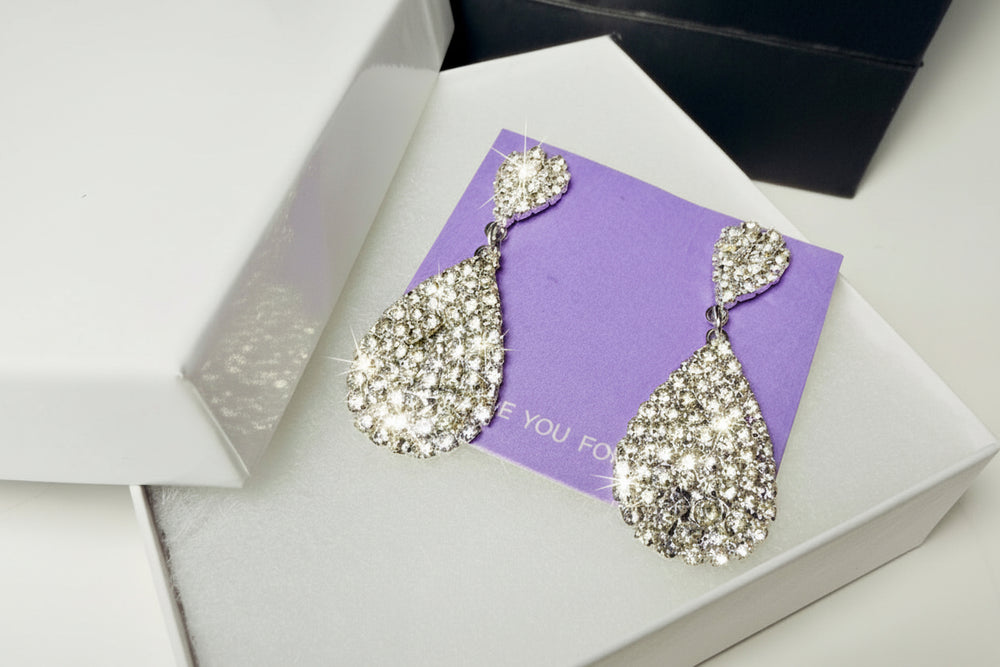 Close-up of sparkling teardrop statement earrings with high-quality crystals and silver-tone finish for weddings.'