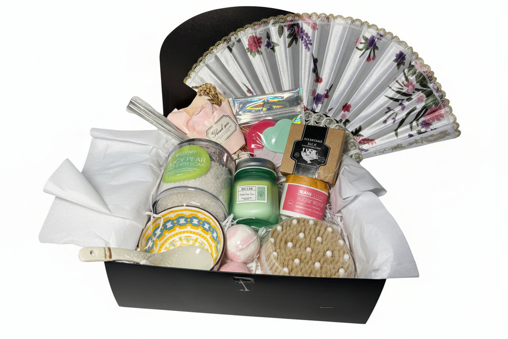 Gift basket with candles, a fan, and other items on a white background
