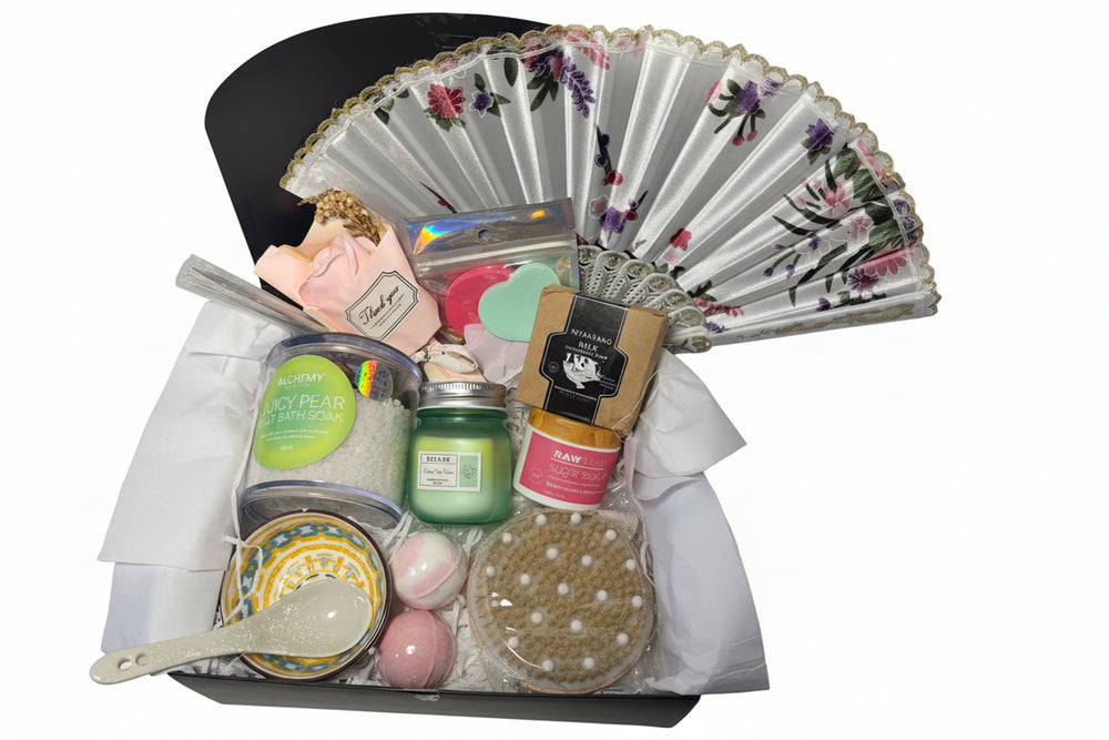Luxury teal and gold spa gift basket for women featuring a designer hand fan, aromatic candle, bath bombs, and a ceramic bowl set in a premium birthday arrangement.