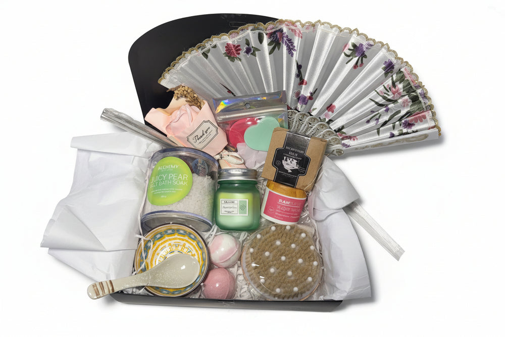 Luxury teal and gold spa gift basket for women featuring a designer hand fan, aromatic candle, bath bombs, and a ceramic bowl set in a premium birthday arrangement.