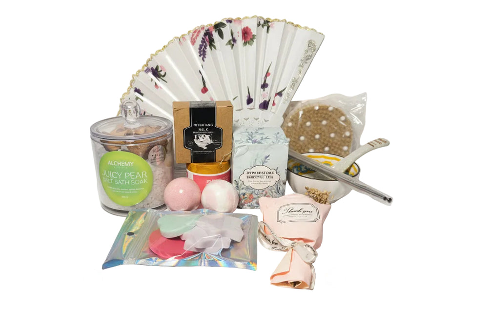 Luxury teal and gold spa gift set for women featuring a designer hand fan, aromatic candle, bath bombs, and a ceramic bowl set in a premium birthday arrangement.