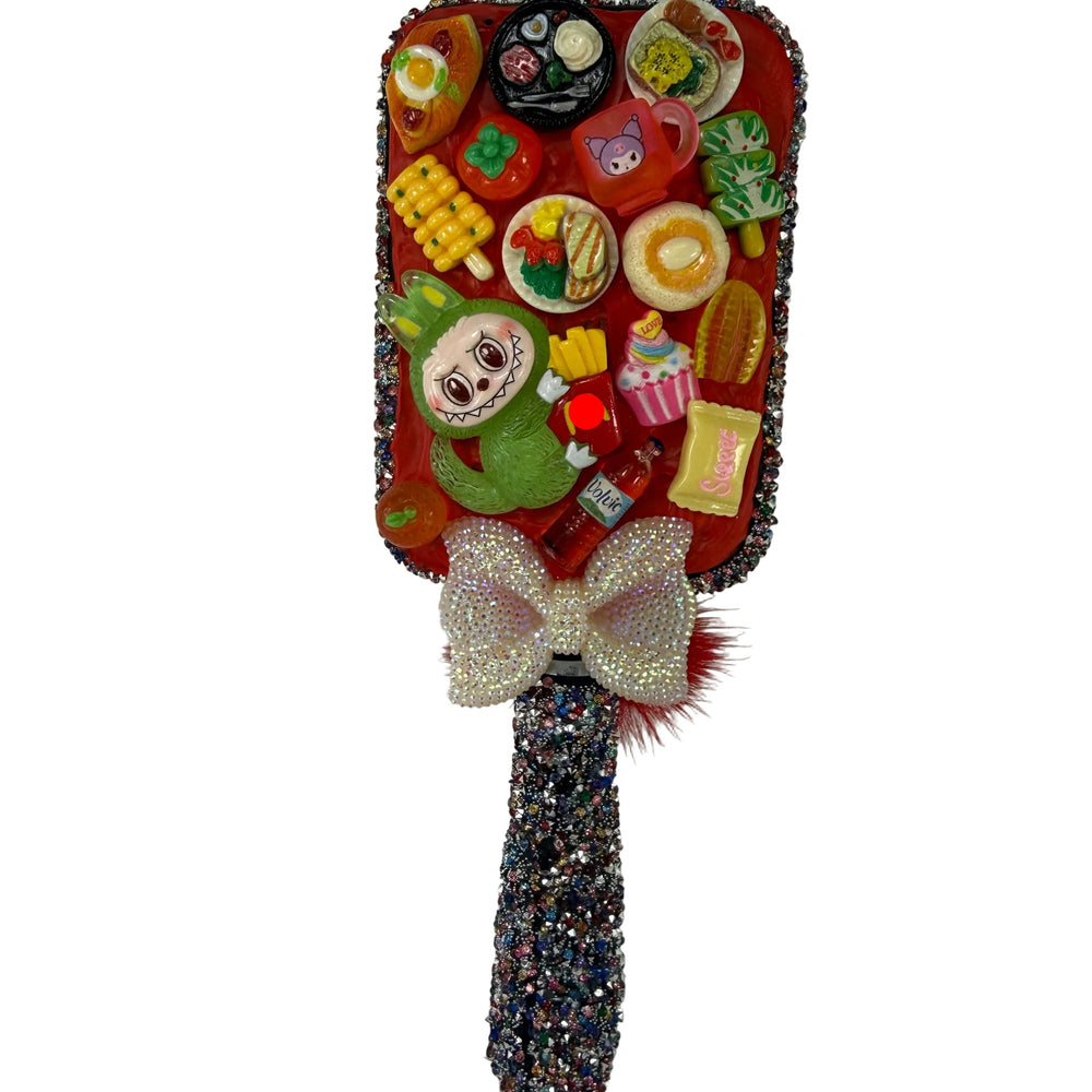 Kawaii-inspired decorative hairbrush with fruit charms and white bow, front view