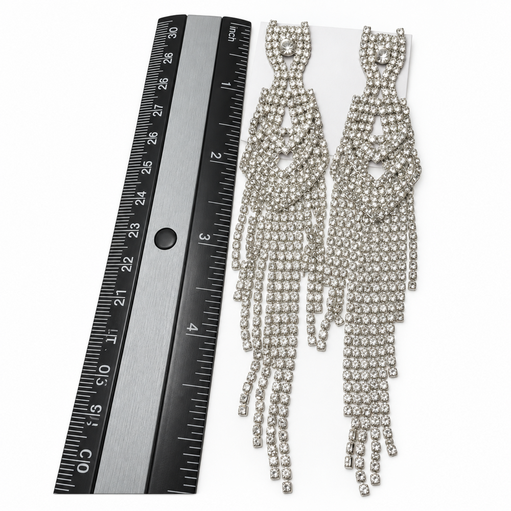 Long silver rhinestone waterfall earrings shown beside an inch ruler for size reference