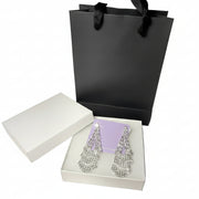 Luxury silver rhinestone dangle earrings displayed with premium white gift box and black paper bag