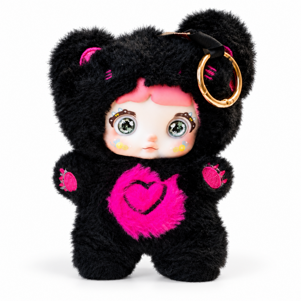 Nommi black furry plush doll keychain with bright pink heart patch, embroidered paw details, and collectible-style design.