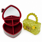 Open red heart jewelry box with mirror and divided storage compartments shown beside a yellow-green decorative mini purse.