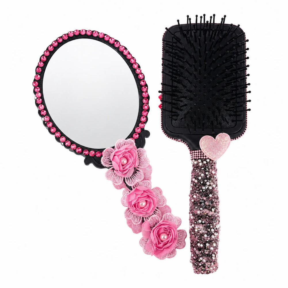 Pink hand mirror and black paddle brush with rhinestones, fabric flowers, pearl accents, and heart detail.