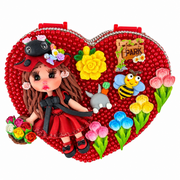 Red heart-shaped jewelry box decorated with flowers, bee, garden details, and a handmade doll in a red outfit.