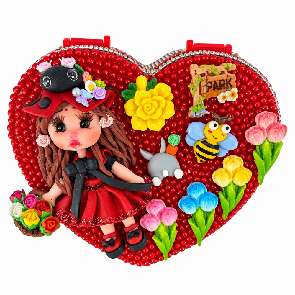 Red heart-shaped jewelry box decorated with flowers, bee, garden details, and a handmade doll in a red outfit.