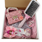 Set of pink accessories including a purse, hairbrush, and hair bow in a box.