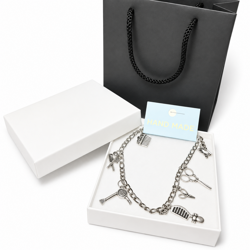 Silver-tone hairdresser charm anklet displayed in a white gift box with scissors, comb, mirror, and styling tool pendants.