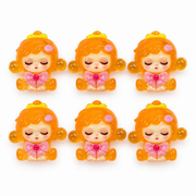 Six translucent orange Sleepy Doll resin flatbacks with pink bows on a white background.