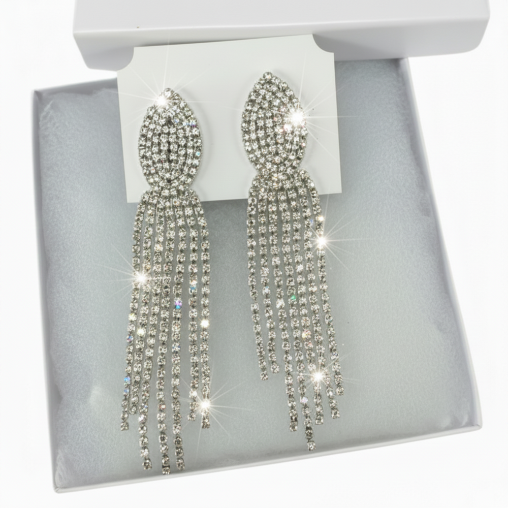 Sparkly rhinestone drop earrings presented in a jewelry box with tissue paper and gift bag.
