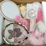Women's gift set items: rose soap, butterfly hair clips, fluffy hair ties, cozy socks, and anklet bracelet.