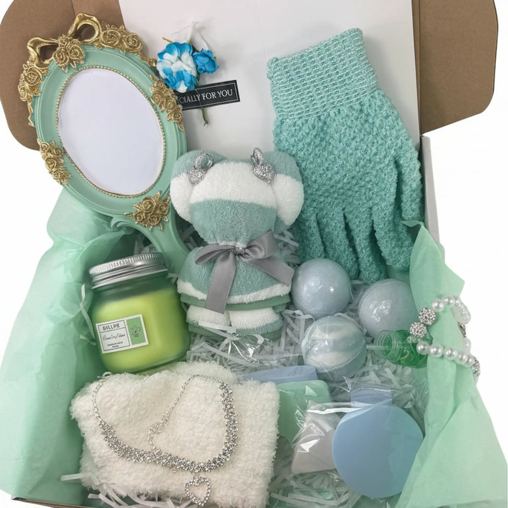 Women's self-care gift basket featuring mint green bath accessories, fuzzy socks, and a handmade keychain