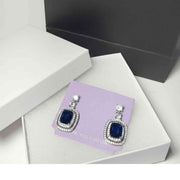 close-up of blue stone drop earrings showing faceted gemstone details